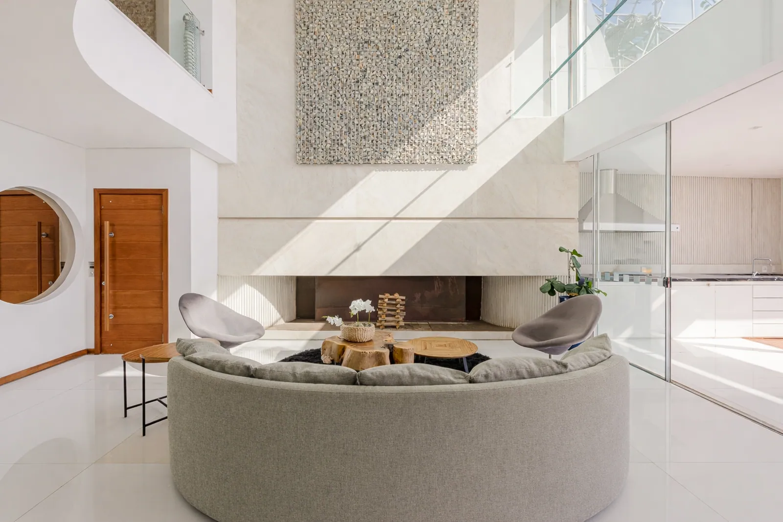 Curved sofa under the double-height ceiling, light from above