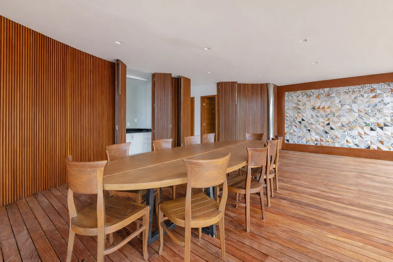 Dining room panelled in wood, a mineral mural along the wall