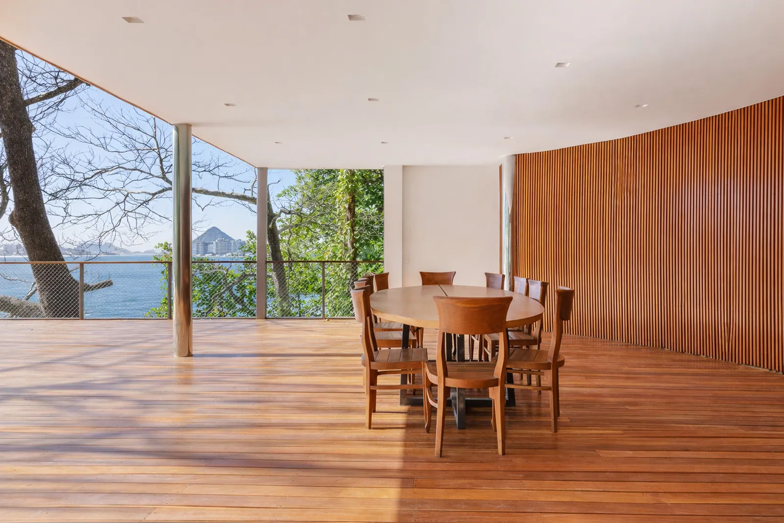 The dining room opening to the sea through the trees