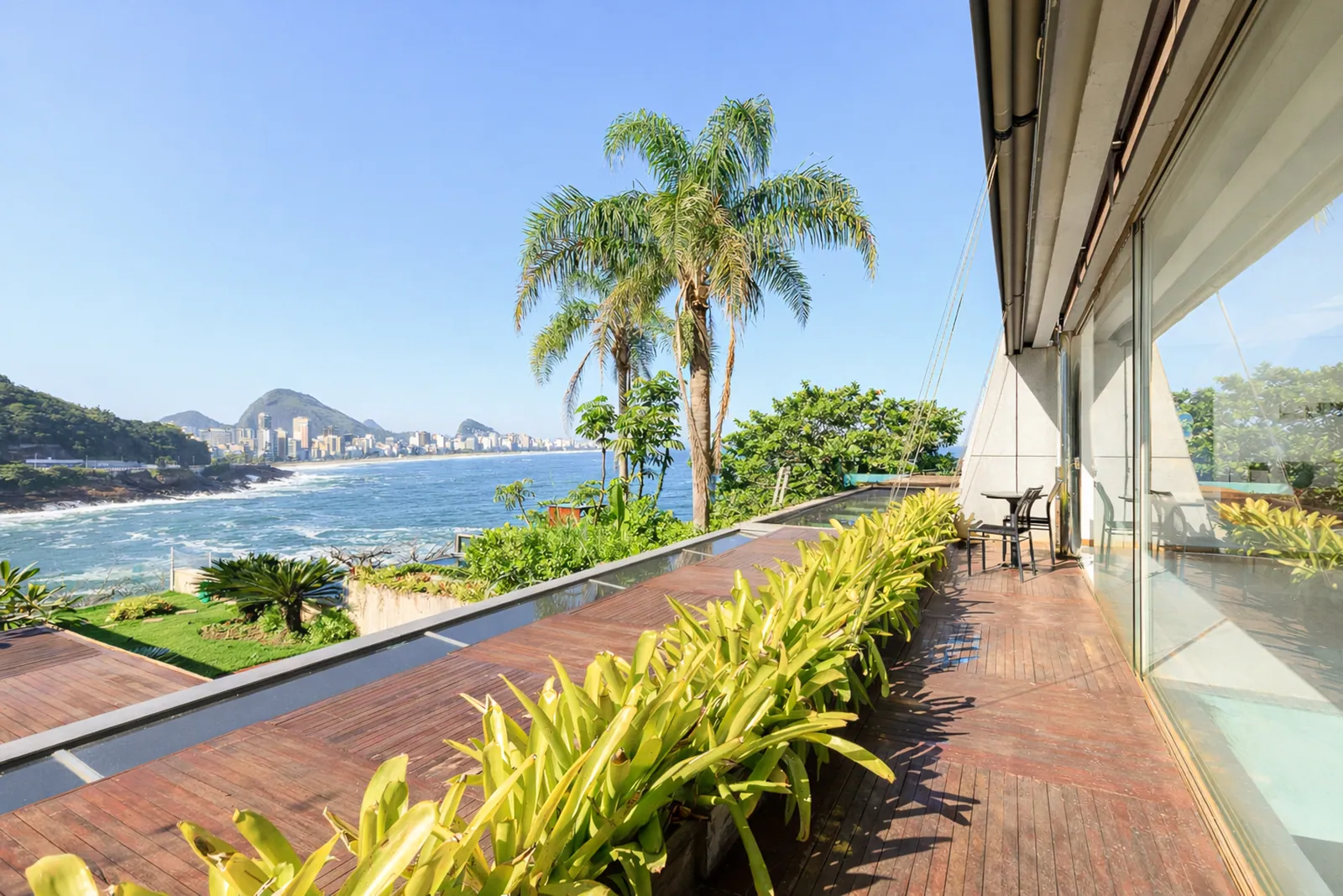 The upper deck above the garden, palms and the sea beyond