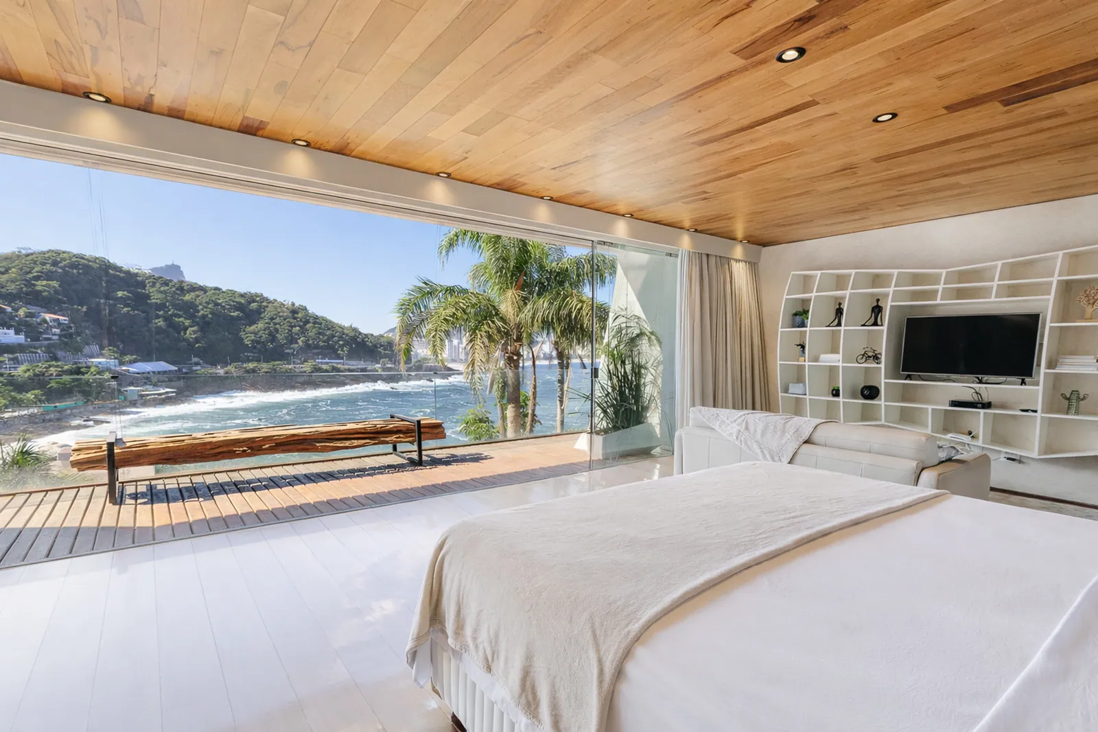 Bedroom beneath the wood ceiling, the sea along the whole window