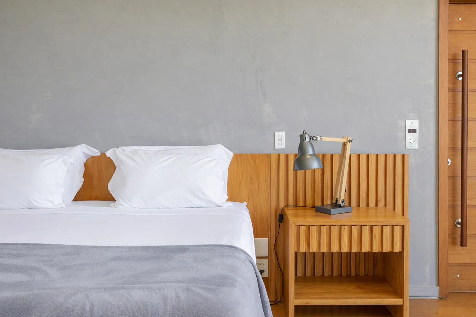 Bedroom with a wooden headboard and reading lamps